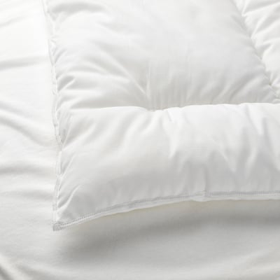 Close-up of plush, white pillow on crisp white bedding, showcasing quality materials and stitching.