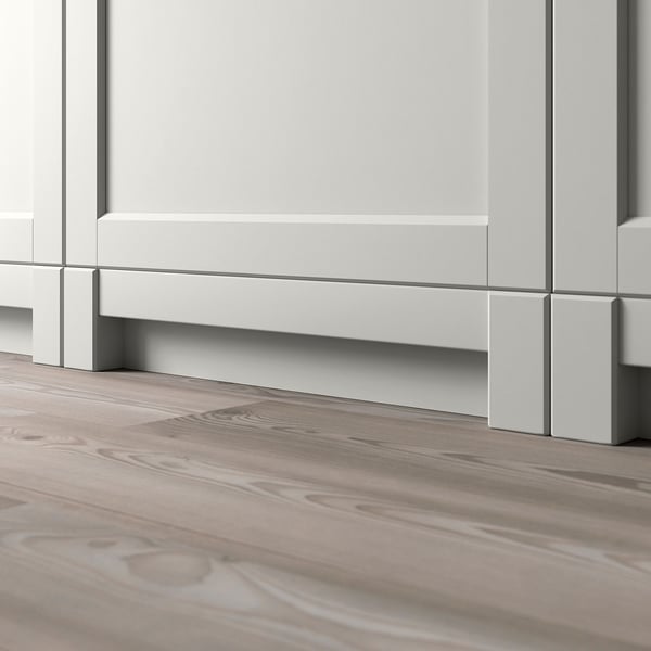 White kitchen plinth with wooden floor, showing integrated legs.