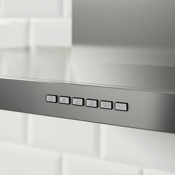 Stainless steel range hood with control panel displaying power and fan speed settings, indicating its functionality for kitchen ventilation.