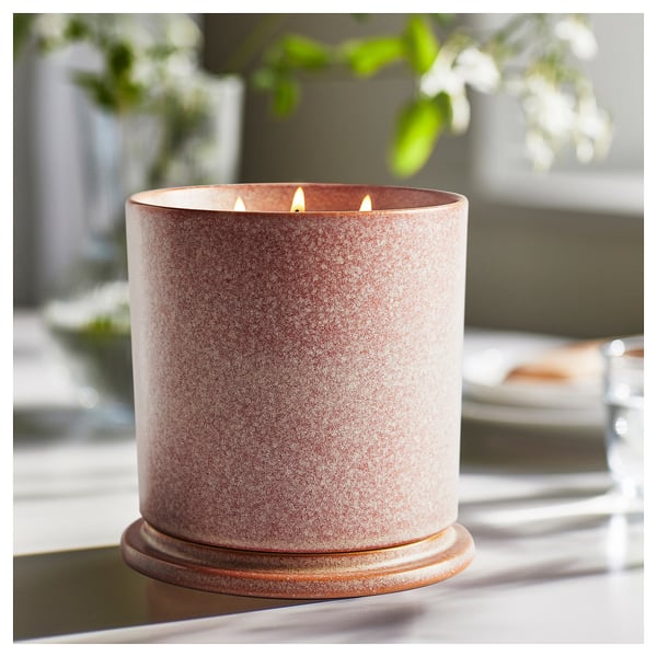 Luxurious LUGNARE scented candle in speckled orange and white ceramic jar, lit with three wicks.