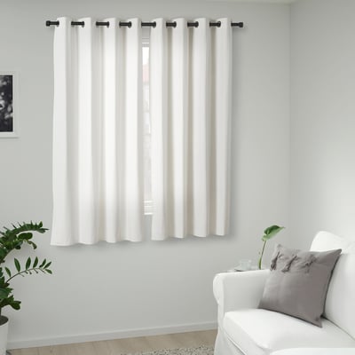 Minimalist room with MERETE curtains, white armchair, grey pillow.