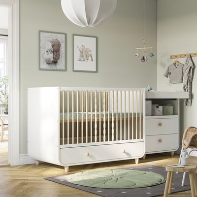 Baby nursery with MYLLRA cot, changing table, play mat, and cosy decor.