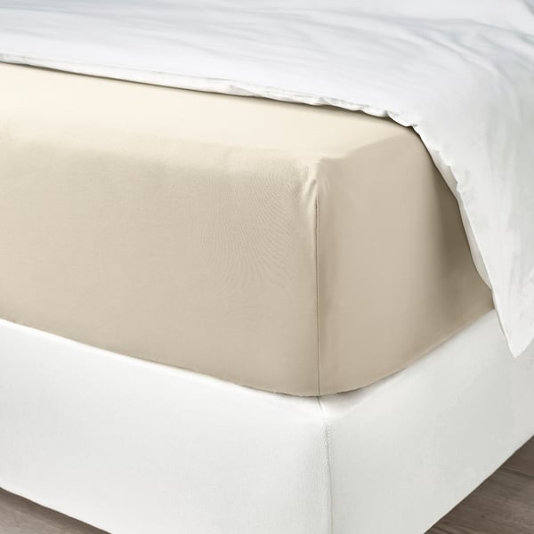 Bed with beige, luxurious sateen sheets, showing folded top for comfort and easy use.