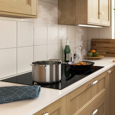 Modern kitchen with NEDERSTA induction hob, cooking multiple pots and pans, sleek and spacious.