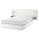 Modern white bed with attached headboard, shelves, and storage drawers.
