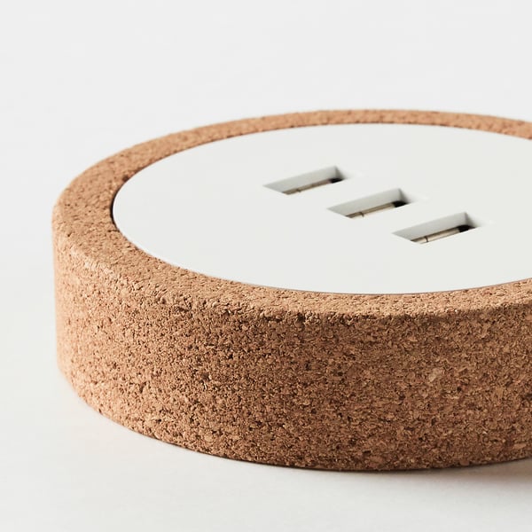 Circular cork-based usb charger with 3 ports. Natural texture, sleek design.