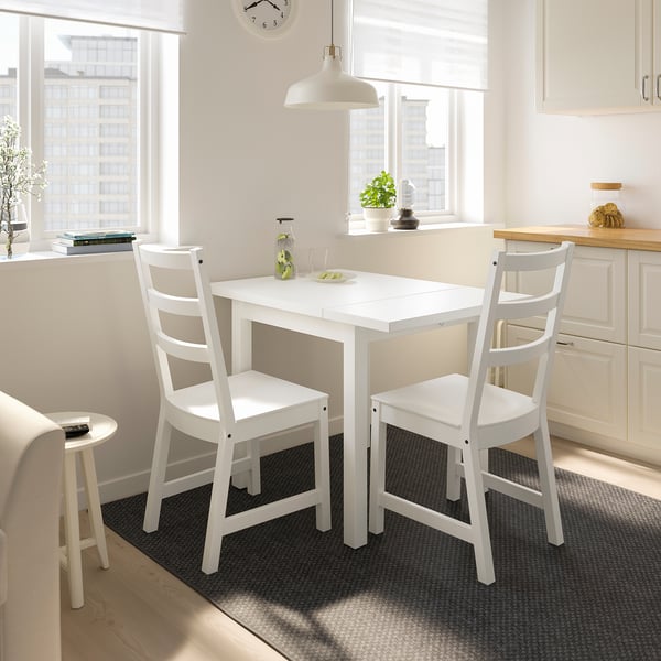 Small white dining set in bright room. NORDVIKEN table seats 4, chairs have high backs.