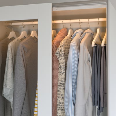 Modern wardrobe with automated led lighting, illuminating clothes racks.