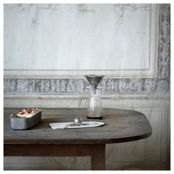 Silver ÖVERST coffee philtre on rustic table with glass server & coffee grounds.