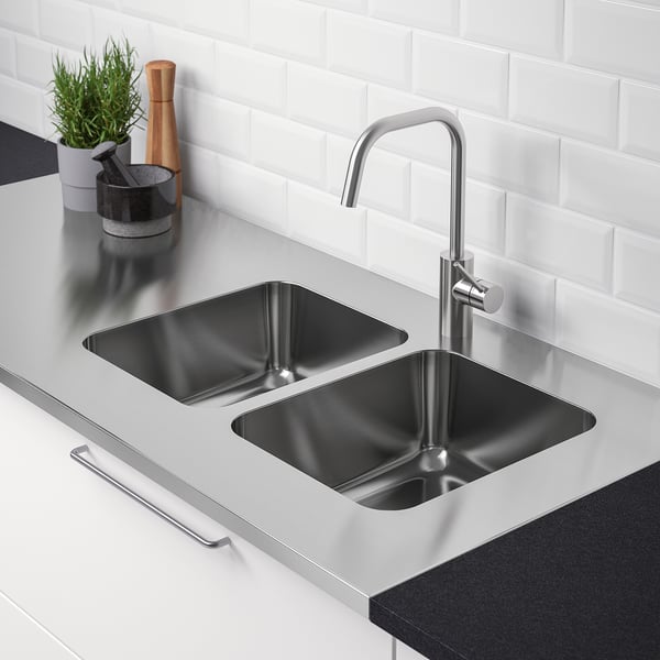 Stainless steel double sink with modern tap, set in sleek countertop, perfect for kitchen or laundry use.