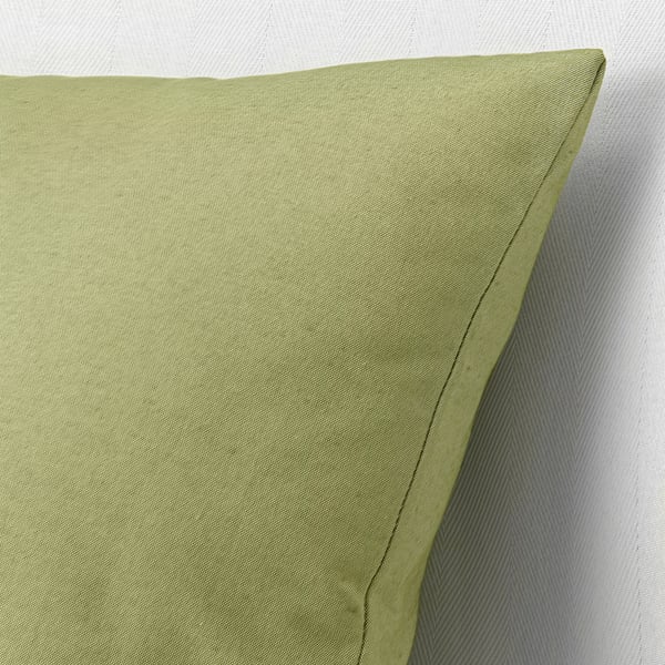 Green cushion with quality stitching. Natural texture, recycled fabric.