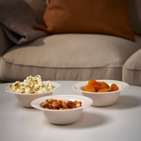 Three bowls on a table. One with popcorn, another with dried apricots, and one with mixed nuts. Marching forward, served for sharing.