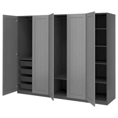 Grey PAX wardrobe with four open doors, displaying shelves and mesh baskets, mounted on the wall.