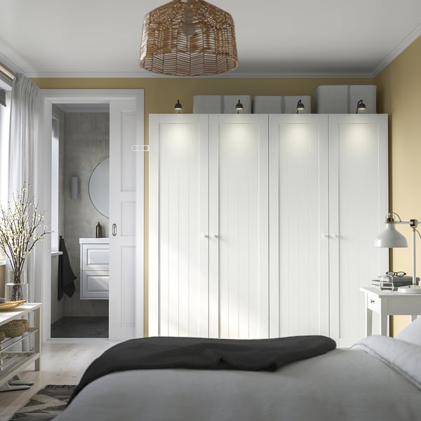 Spacious bedroom with white PAX wardrobe. Bed near, black covers.