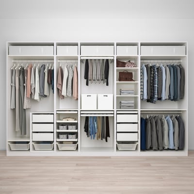 Walk-in closet with open shelves, hanging rails, and drawers, neatly storing various clothes and accessories.