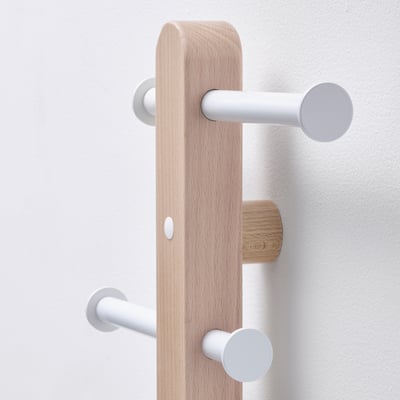 Modern coat rack with light wooden base, three white hooks. High-quality, minimalist design.