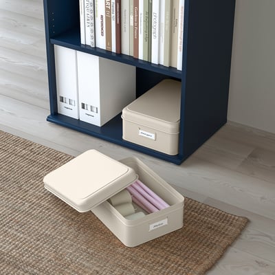 Blue shelf with white boxes storing files and books. One box open on the floor revealing coloured folders.