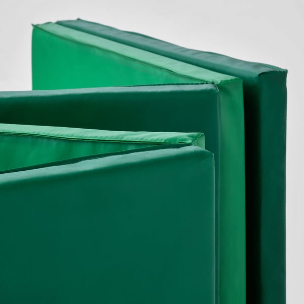 Foldable green gym mat with padded surface, designed for safety and comfort.
