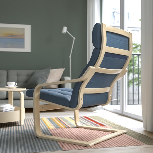 Modern living room with blue POÄNG armchair, high back support, near window.