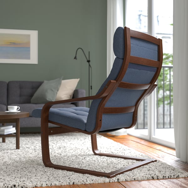 Modern living room with blue cushioned chair, wooden arms, near window and grey sofa.