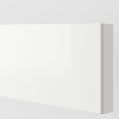 White, high-gloss kitchen cabinet front in pristine condition, reflecting light, with smooth and clean surface.