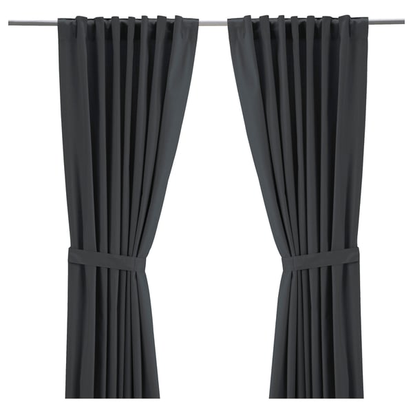 Two dark grey RITVA curtains hang straight with rod pockets and tiebacks. Made from 100% cotton, they provide privacy and light control.