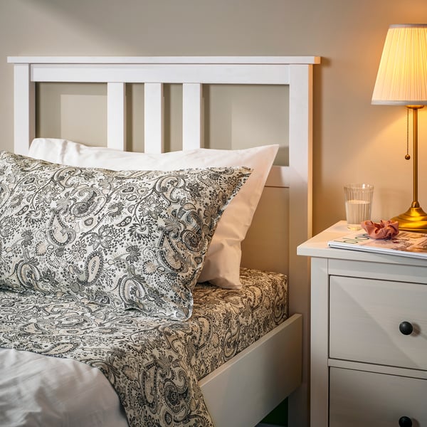 RODGERSIA paisley bedset with bedside table, lamp, and personal items.