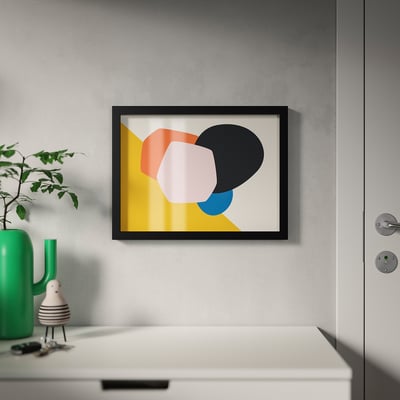 Framed modern art print, mounted on wall. Displayed near a green vase with plant. Hangs via adhesive hook.