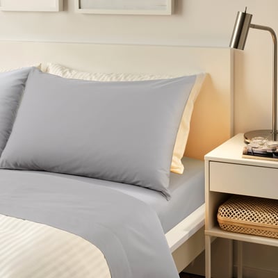 RÖNNVECKMAL grey bedding set: crisp cotton percale sheets & pillowcases, neatly made on large bed, with minimalist bedside table.