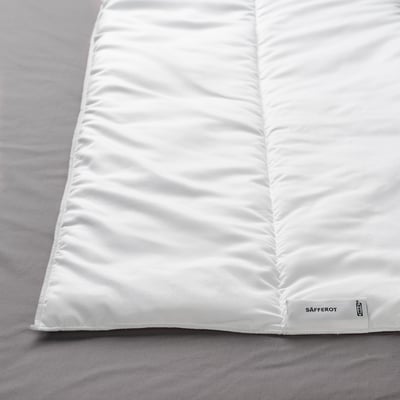 Closet a pristine white SÄFFEROT duvet, neatly folded, showcasing its smooth, inviting texture.