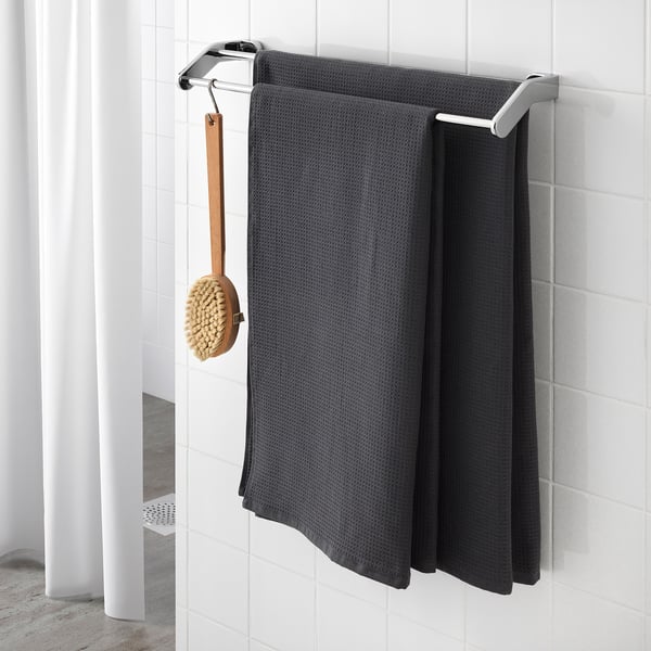 Towel rack with dark grey towels and wooden brush.