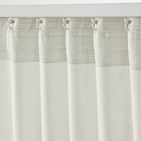 White curtains hang with hooks, allowing light through, providing privacy, and insulating windows.