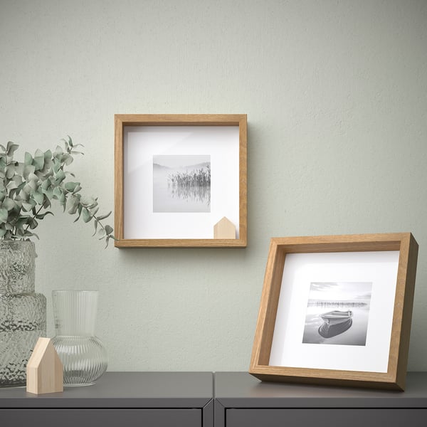 Two wall photos: art & beach, plant near.