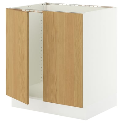 A white SEKTION kitchen cabinet with light oak doors and integrated hinges, designed for easy assembly and strong durability.