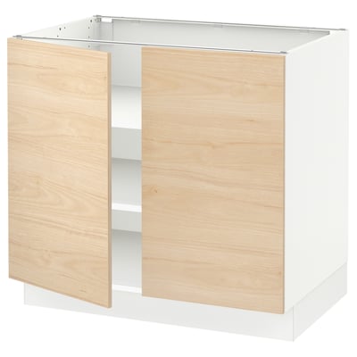 A modern kitchen cabinet named SEKTION with light ash-colored doors and a white frame. It adjustable shelves and snap-on hinges.