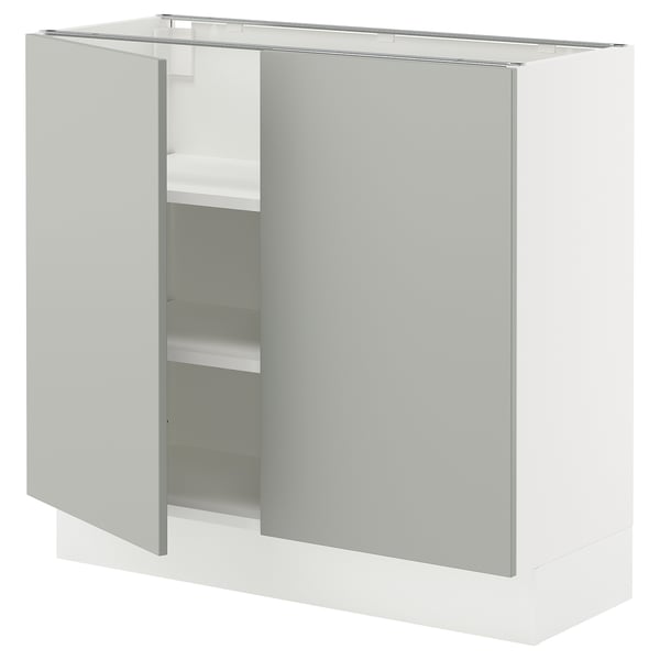 Modern white kitchen cabinet with light grey door and shelves.