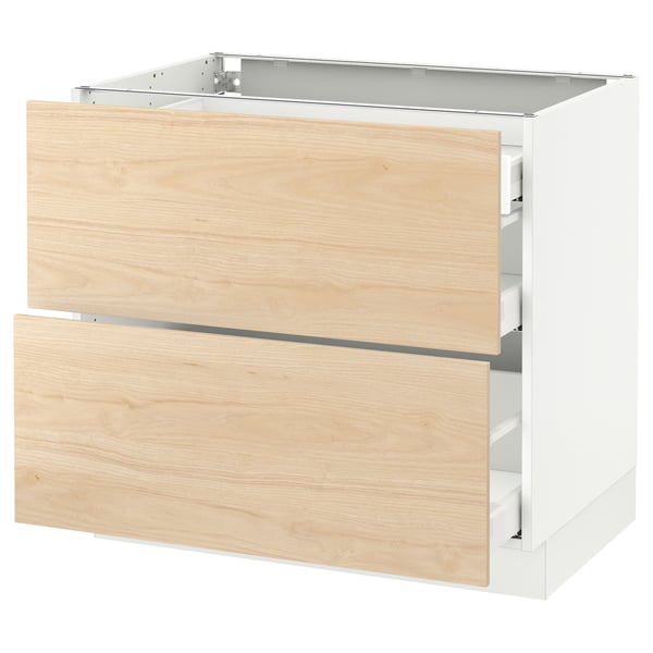 Light-colored wooden drawers on white cabinet base.