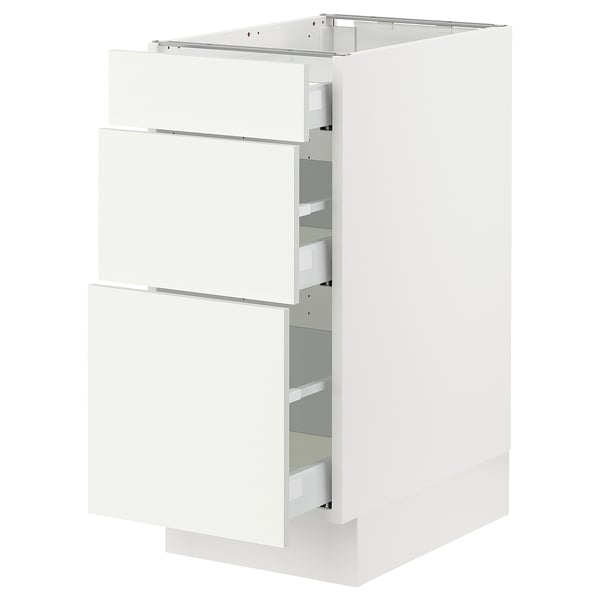 White SEKTION cabinet with three open drawers.