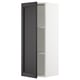 A white wall-mounted kitchen cabinet with a tall, dark wood-finished door partially open, revealing glass shelves.