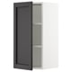 White wall cabinet with open black door and shelf.