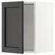 An open black stained wooden cabinet with a rectangular door featuring bevelled edges. The door is hinged to a white cabinet.