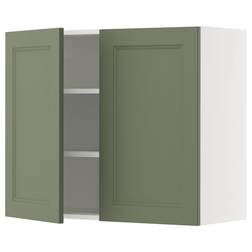 A green kitchen cabinet with one open door revealing shelves.