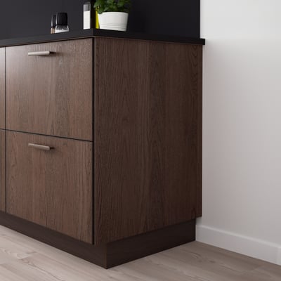 Modern kitchen with dark SINARP cabinets, sleek handles, and a corner plant.