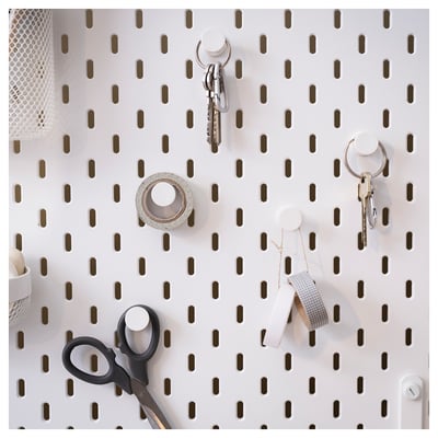SKÅDIS white pegboard with black hooks holds keys, scissors, and tape. Organised and modern wall storage.