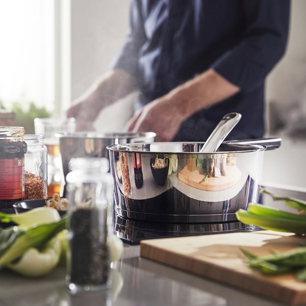 Cooking with SLÄTROCKA saucepan with detachable handle on stovetop, surrounded by ingredients and spices.