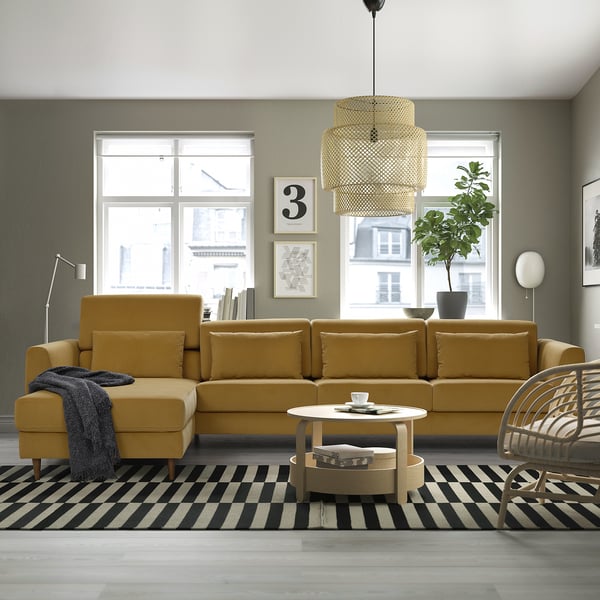 Modern living room with large yellow SLATORP sectional sofa, chaise longue, tiered lampshade, black & white rug, coffee table, and large windows.