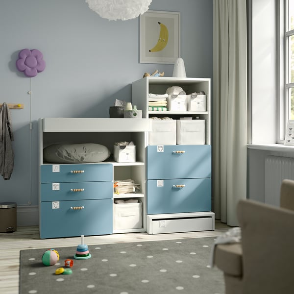 A SMÅSTAD blue & white nursery with changing table, storage, baby essentials, toys, and wall decor.