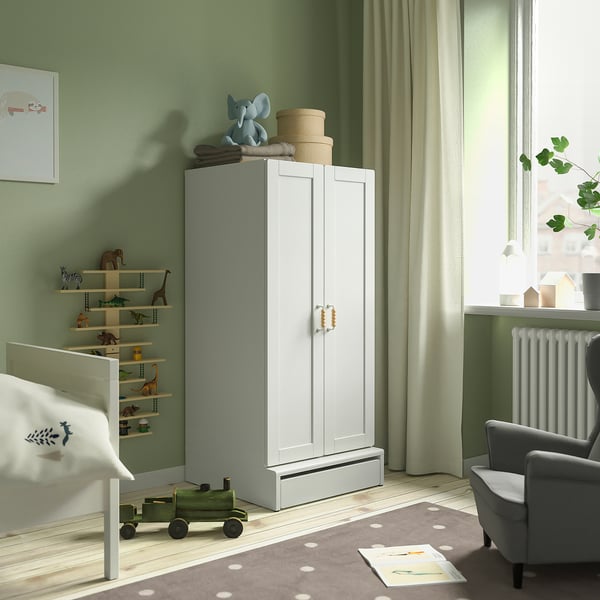 Kids room with SMÅSTAD white cabinet, toy shelf, grey rug, and grey armchair.
