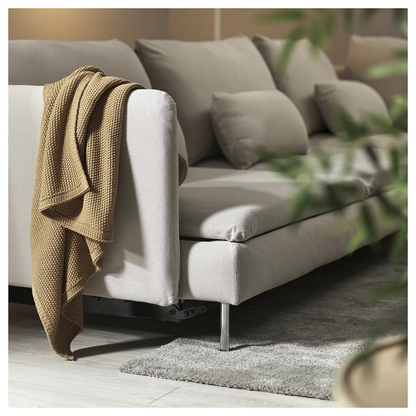 Modern grey sofa with beige blanket, plush cushions, metal legs, cosy and stylish.