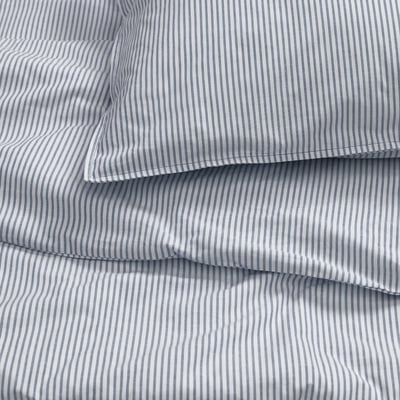 Close-up view of neatly folded, high-quality striped bedding. Thin, even lines and smooth fabric texture evident.